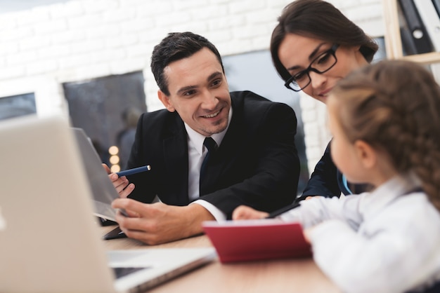 Realtor Showing Plan on Laptop to Mother and Kid.