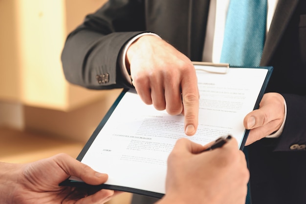 Realtor shows the finger where you need to sign.