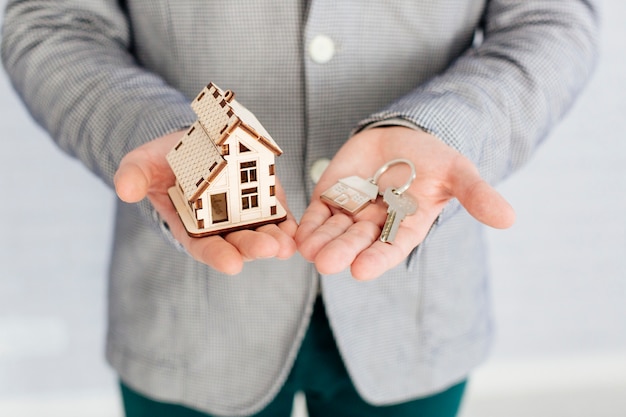 Foto agente immobiliare con casa figurine e chiave