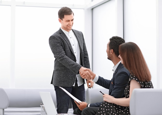 Realtor and the young couple shaking hands with each other