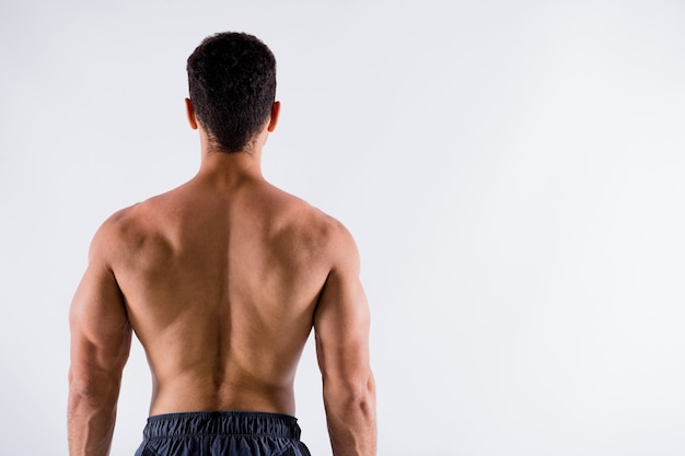 rear back behind view of sportive tanned guy physical culture steroid protein demonstrating muscles