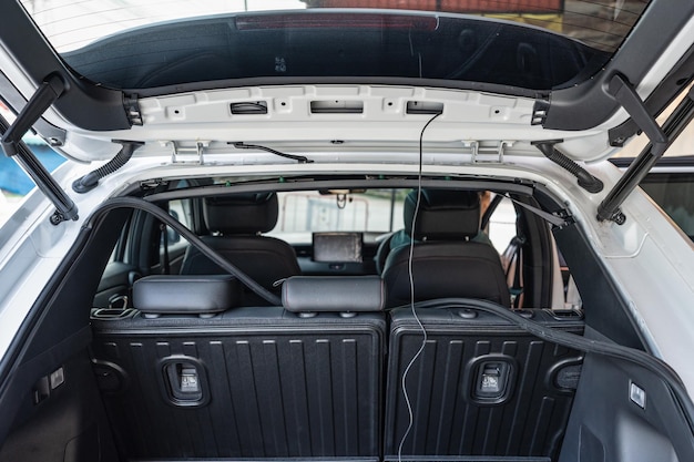 Rear of an SUV car with unpack parts and camera equipment installed in workshop