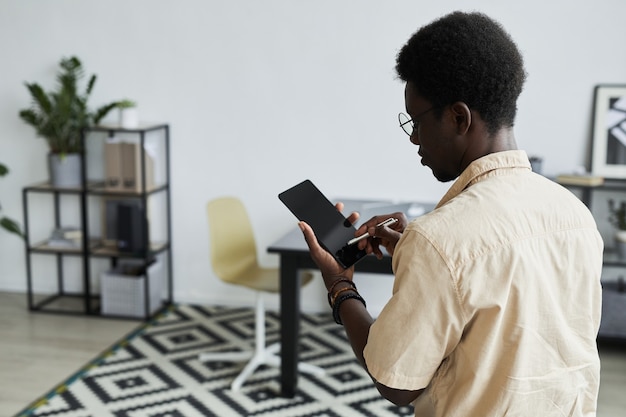 Вид сзади африканского бизнесмена с помощью пера и набора текста на цифровом планшете