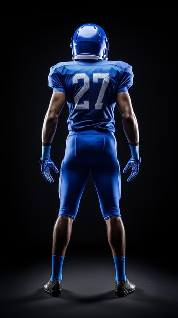 Foto vista posteriore di un atleta di football americano in blu in piedi di fronte a uno sfondo nero full body shoot