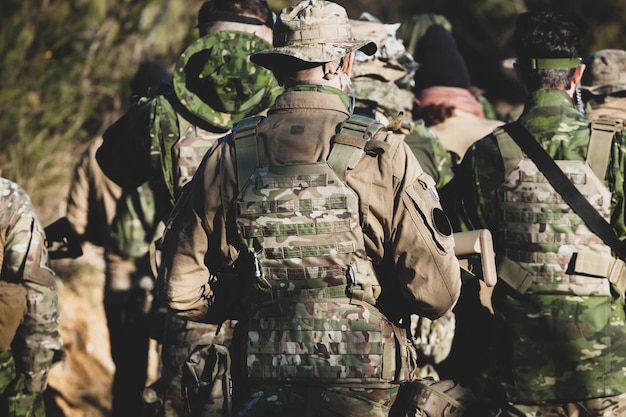 Rear view of army soldiers walking in forest