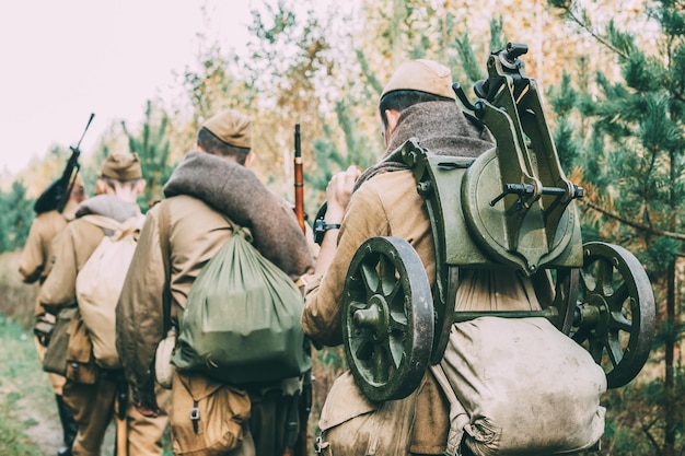 Foto vista posteriore di soldati dell'esercito con le armi che camminano nella foresta