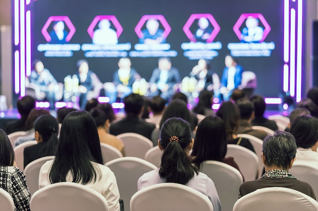 Photo rear view of asian audience joining and listening group of speaker talking on the stage