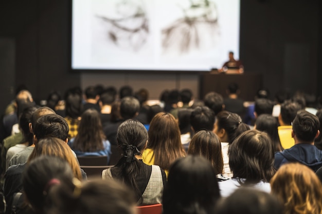 Rear view of Asian audience joining and listening speaker talking on the stage in the seminar