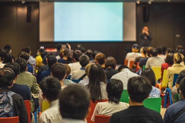 Rear view of Asian audience joining and listening speaker talking on the stage in the seminar