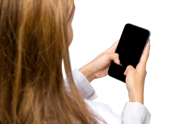 白い背景で隔離の携帯電話を使用してアジアの女性医師の背面図