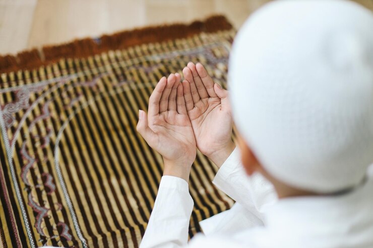 Photo rear view of asian muslim boy praying on prayer mat
