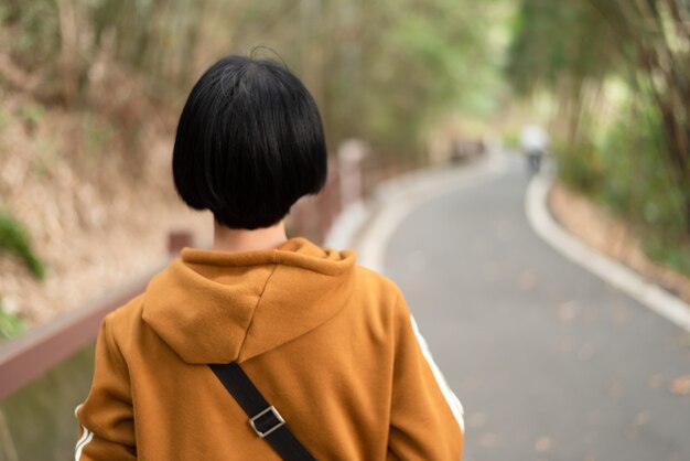 야외에서 길을 걷는 아시아 여성의 뒷모습