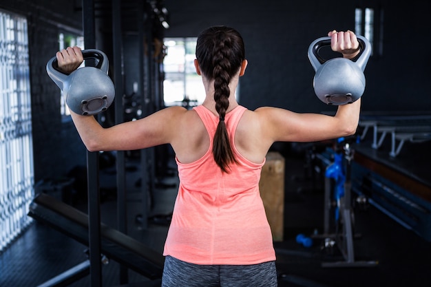 Rear view of athlete holding kettlebell in gym