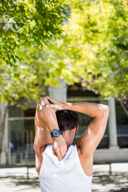 Rear view of athlete stretching his arm