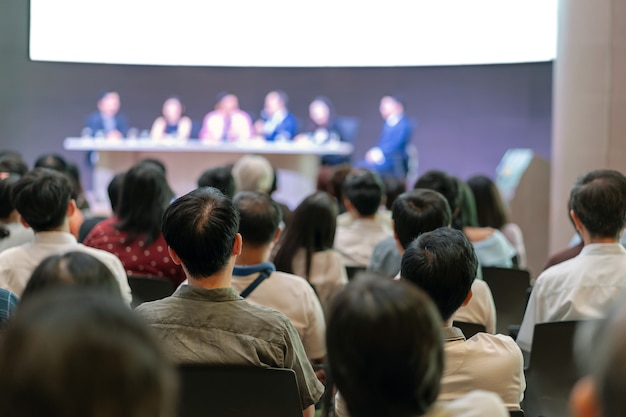 Rear view of Audience in the conference hall or seminar meeting which have Speakers