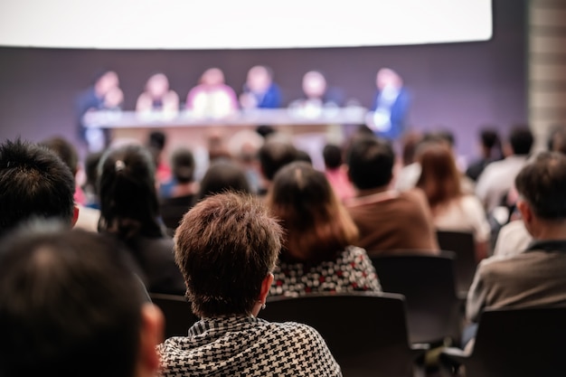 Rear view of Audience in the conference hall or seminar meeting which have Speakers