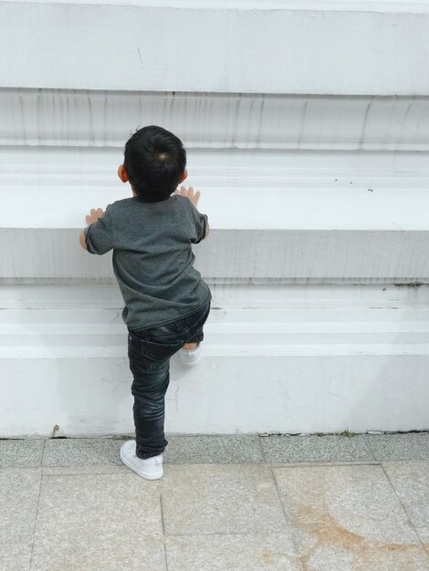 Foto vista posteriore di un bambino che si arrampica sulle scale