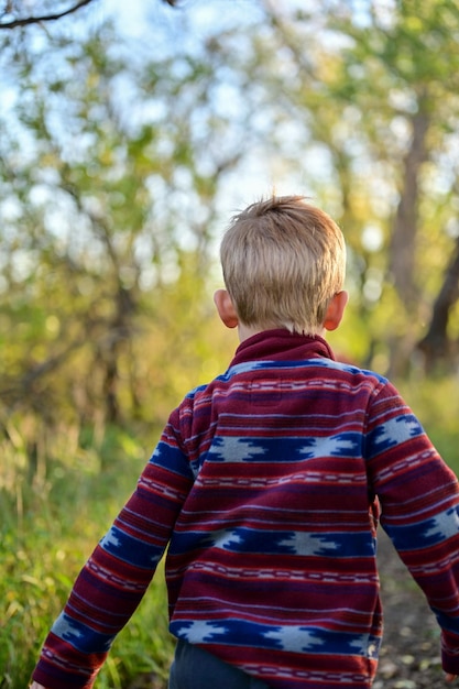 Rear view of a blonde boy having fun outdoors