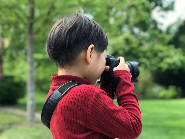 Rear view of boy photographing