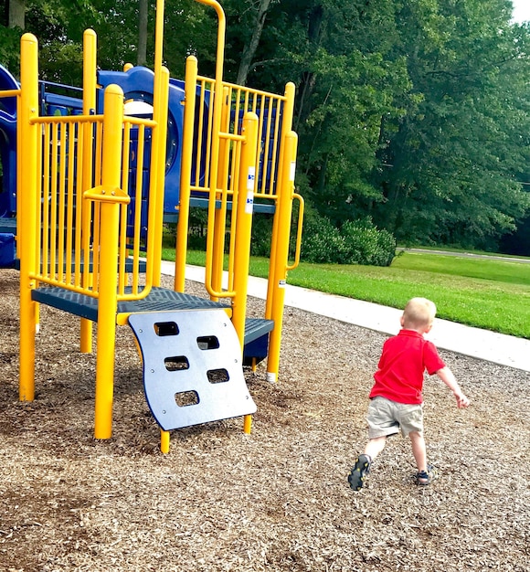 Foto vista posteriore di un ragazzo che gioca nel parco giochi