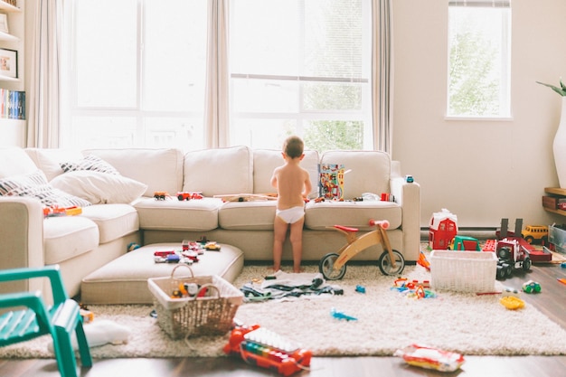 Photo rear view of boy playing with toys in living room at home