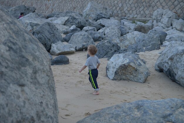 Rear view of boy on rock