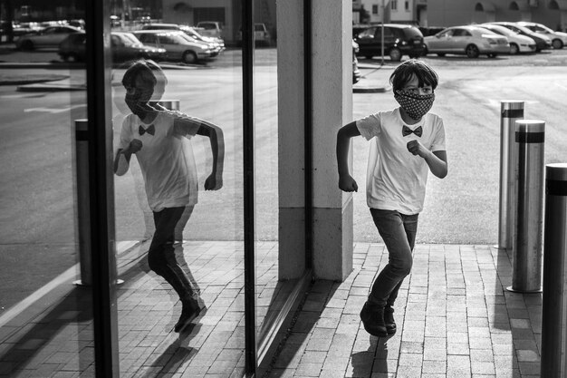 Photo rear view of boy running near glass wall