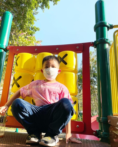 Rear view of boy sitting against yellow wall