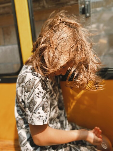 Photo rear view of boy sitting at bus