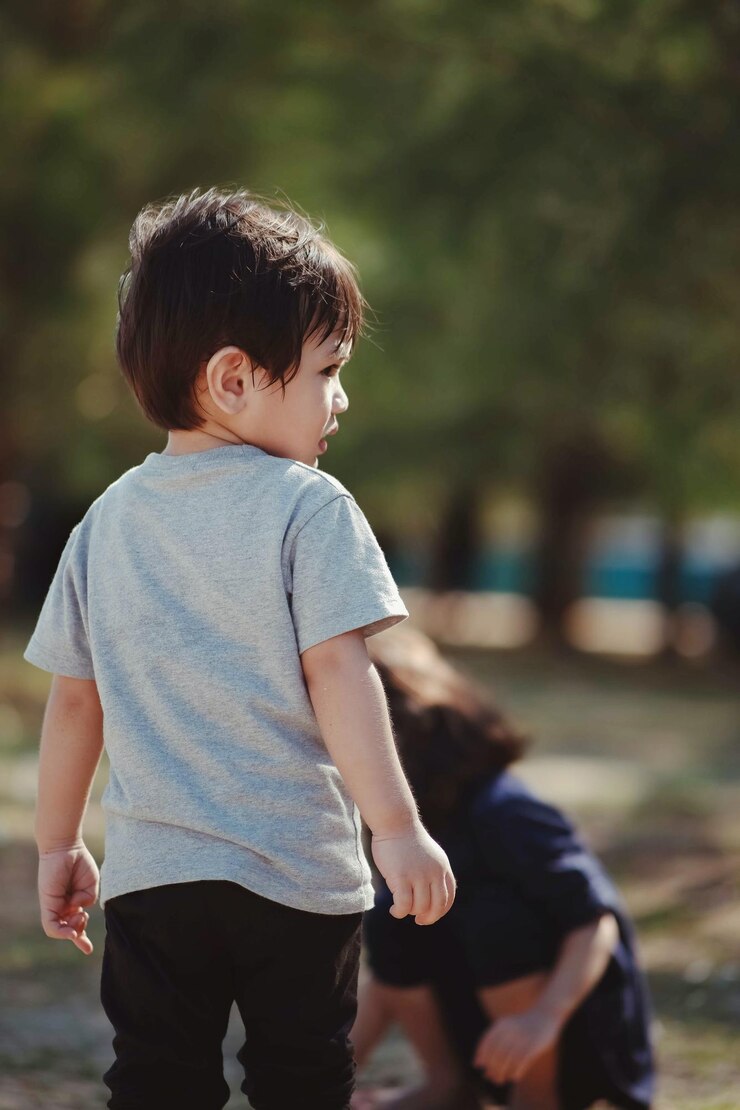 Photo 屋外に立っている男の子の後ろの景色