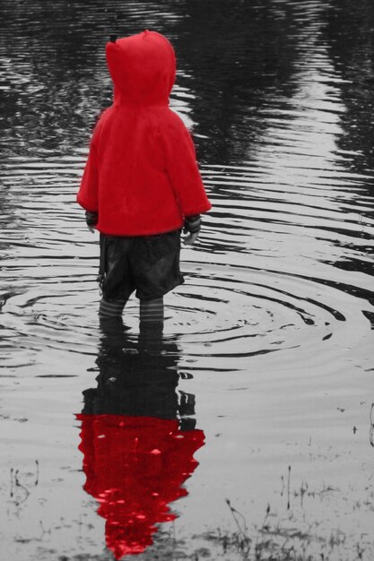 Photo rear view of boy standing in puddle