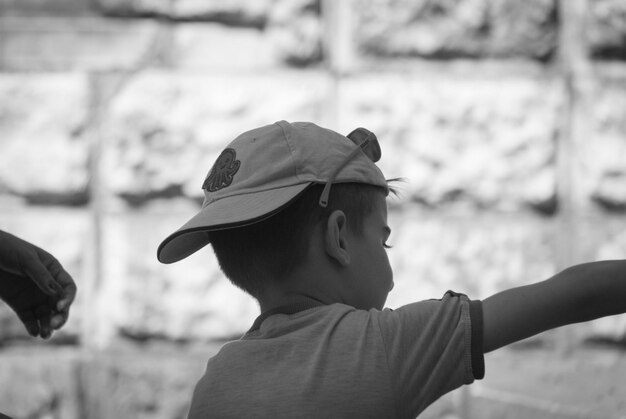 Rear view of boy wearing cap outdoors