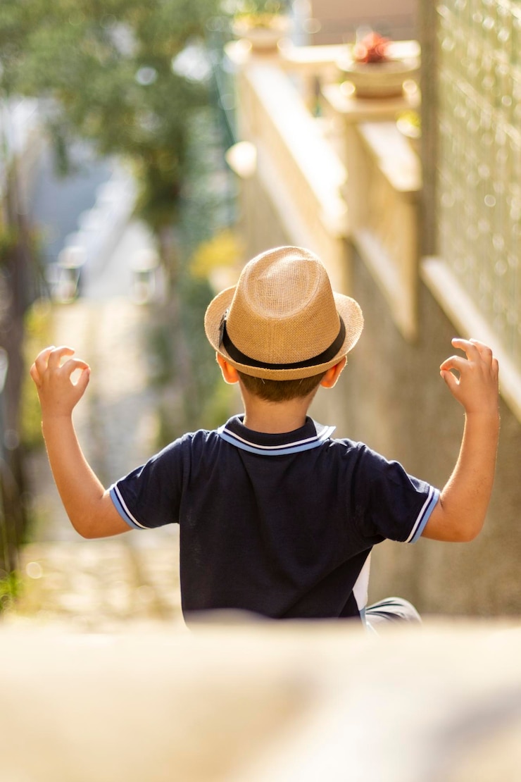 Photo rear view of boy wearing hat sitting on steps