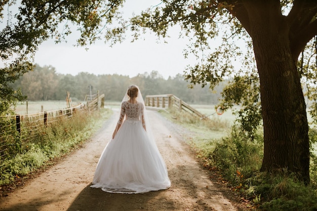 Photo rear view of bride walking on footpath