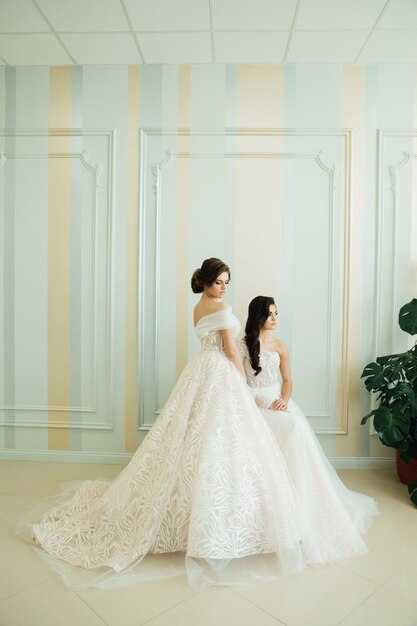 Rear view of brides with bouquets in wedding atelier