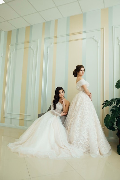 Rear view of brides with bouquets in wedding atelier