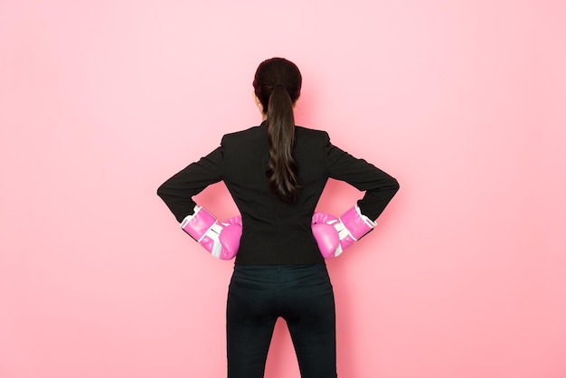 rear view of business lady ready to fight face to the pink background