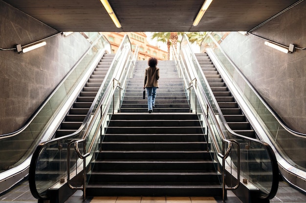 Rear view of business woman walking up the stairs