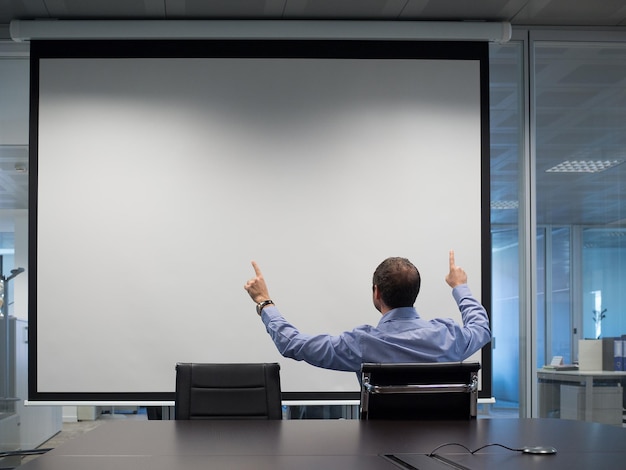 Photo rear view of businessman gesturing during meeting in office