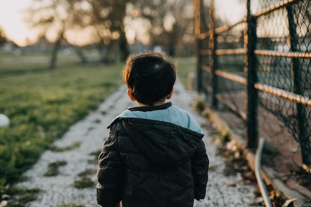 Foto visione posteriore bambino con giacca con cappuccio