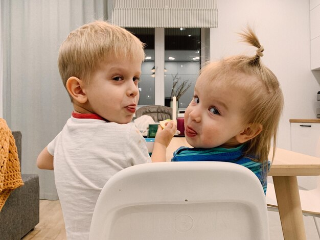 Photo rear view of the children sitting at the table at home