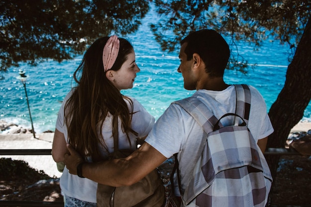 Photo rear view of couple by tree at beach