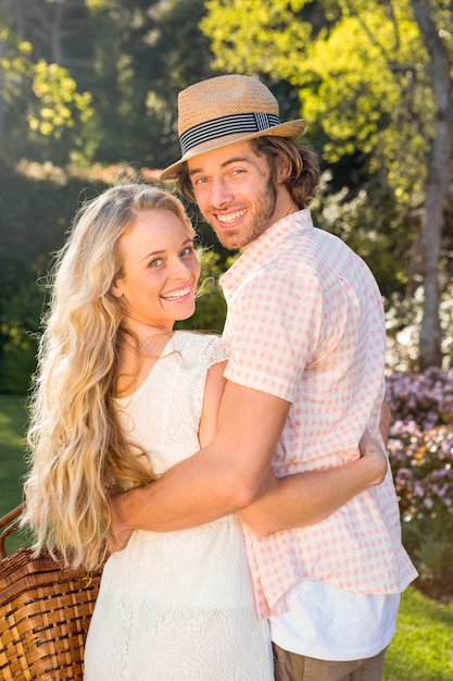 Rear view of a couple holding a picnic basket in the garden