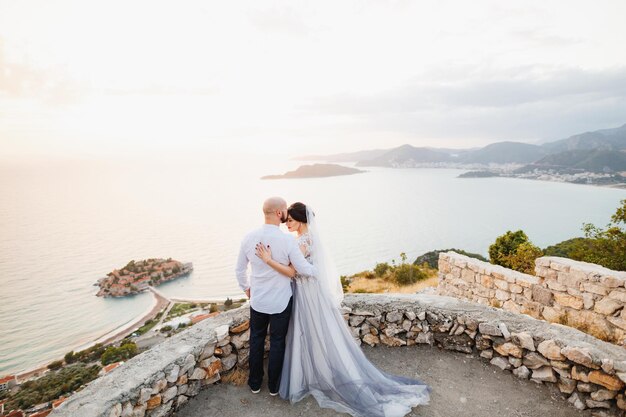 Rear view of couple kissing on shore against sky