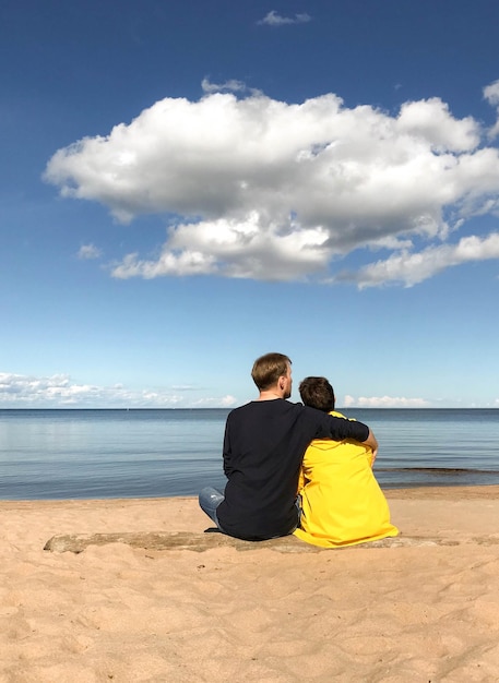 Foto vista posteriore di una coppia seduta in spiaggia