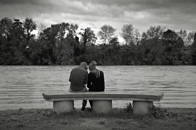 Photo rear view of couple sitting on bench