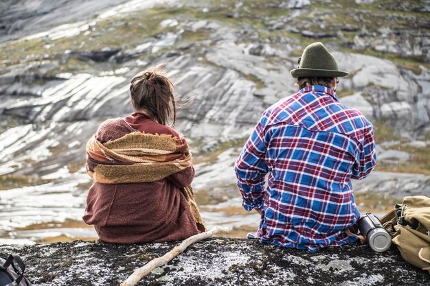 Photo rear view of couple sitting on rock