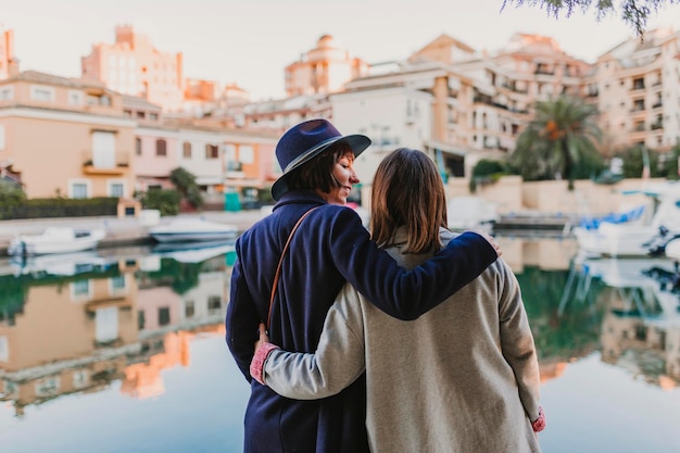 Rear view of couple standing against buildings in city