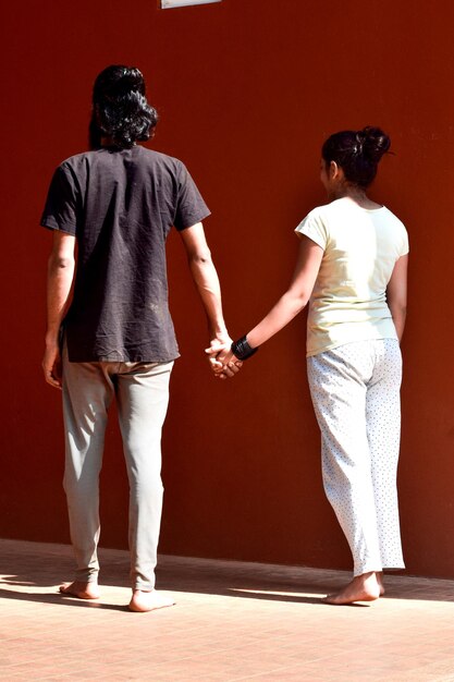 Rear view of couple standing against wall