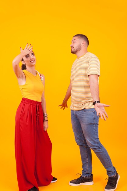 Rear view of couple standing against yellow wall